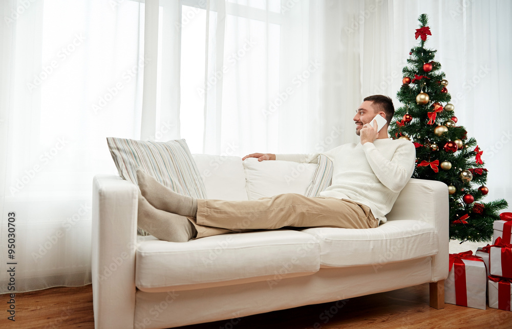 Obraz premium man calling on smartphone at home for christmas