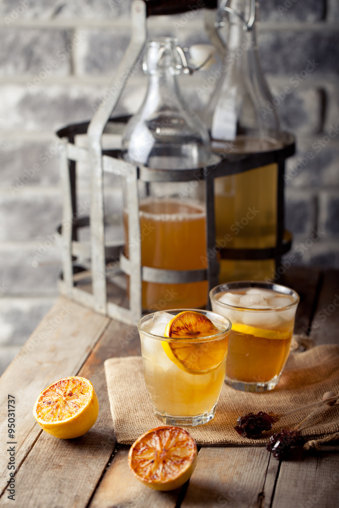 Lemonade in glasses and bottles made of grilled lemons. Cider.