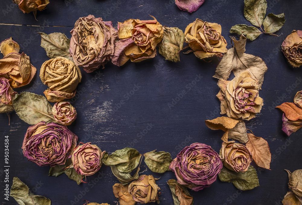 Dried roses with petals, lined frame with space for text on wooden rustic background top view close up Dried roses with petals, lined frame with space for text on wooden rustic background top view close up
