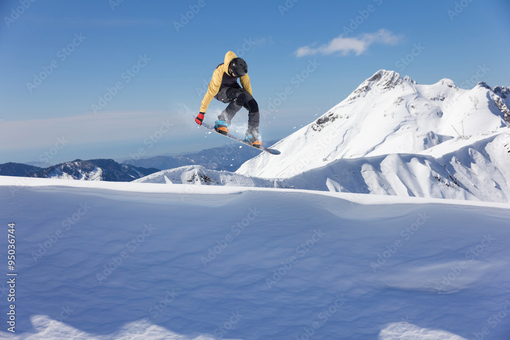 Flying snowboarder on mountains