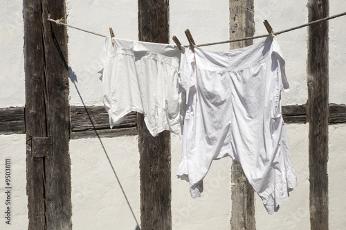 Frisch gewaschene weisse Wäsche hängt zum trocknen in der Sonne.