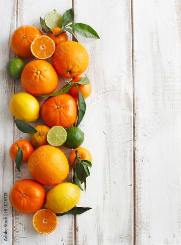 Obraz na plátně Fresh citrus fruits with leaves on wooden background