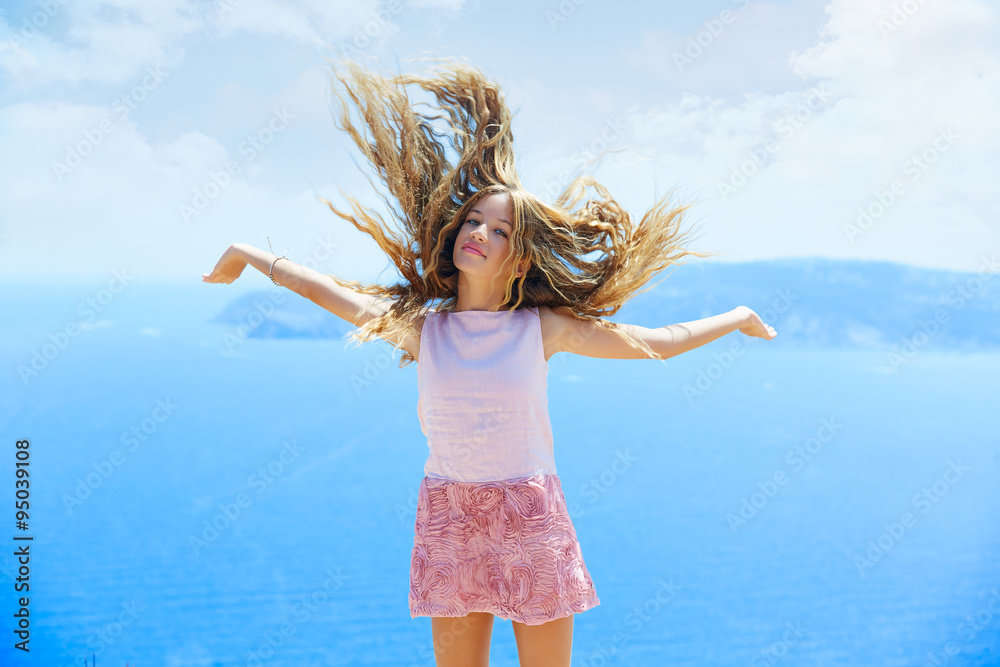 Naklejka premium Blond girl shaking hair on air at blue Mediterranean