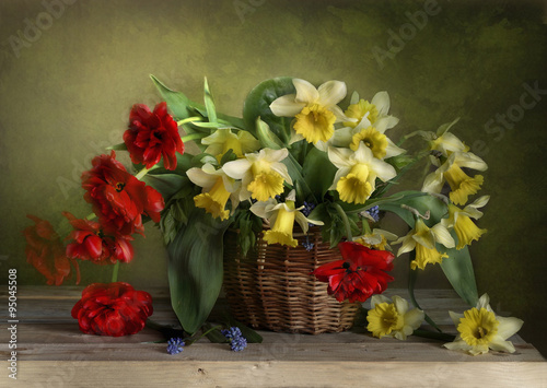Красивый букет весенних цветов из тюльпанов и нарцисс в плетеной корзинке