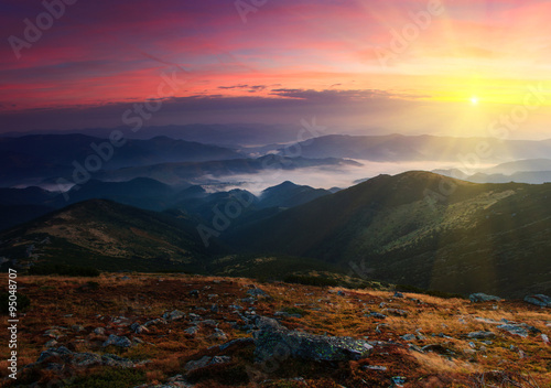 Colorful sunrise in the mountains. Fog in the valley. © vovik_mar