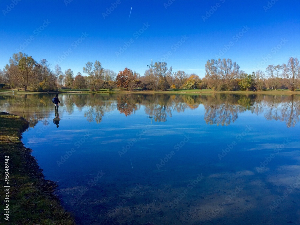 Fototapeta premium Fischer fischt Fische im Feringasee bei München