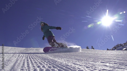 SLOW MOTION: Snowboard girl spraying snow into camera