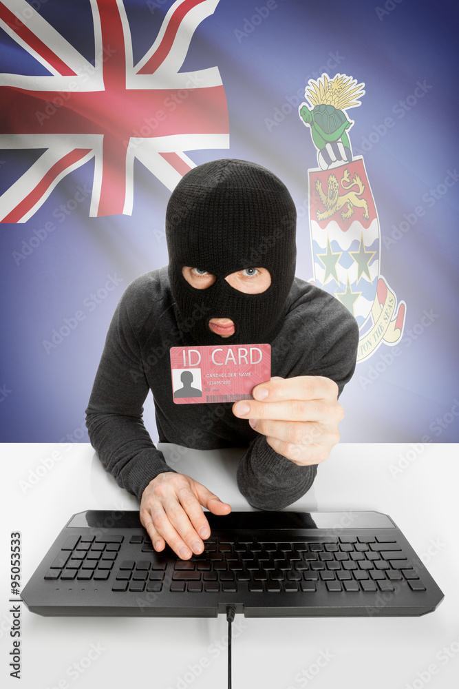 Hacker with flag on background holding ID card in hand - Cayman Islands Hacker with flag on background holding ID card in hand - Cayman Islands