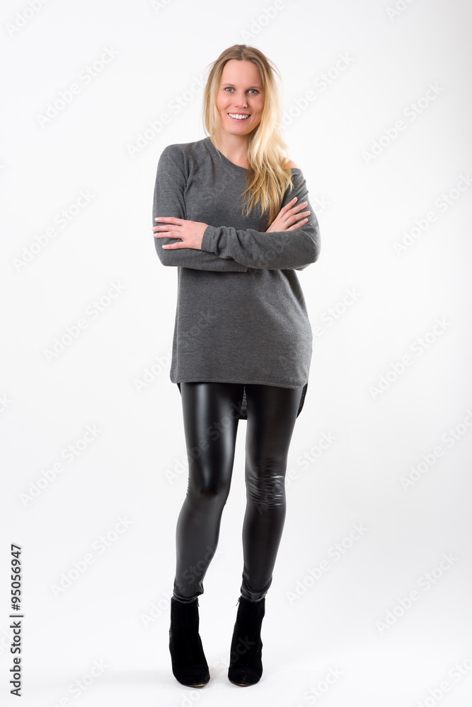 Blond fashion woman in slim black pants posing in front of white Blond fashion woman in slim black pants posing in front of white