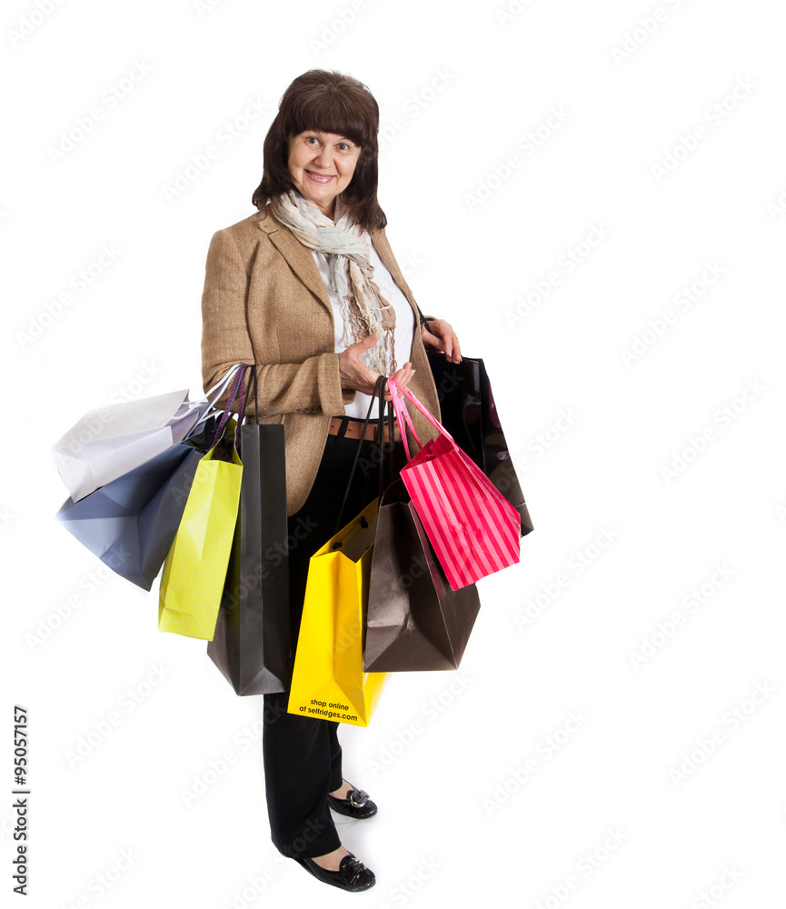 Mature good looking woman with lots of shopping bags, happily smiling after shopping. Mature good looking woman with lots of shopping bags, happily smiling after shopping.
