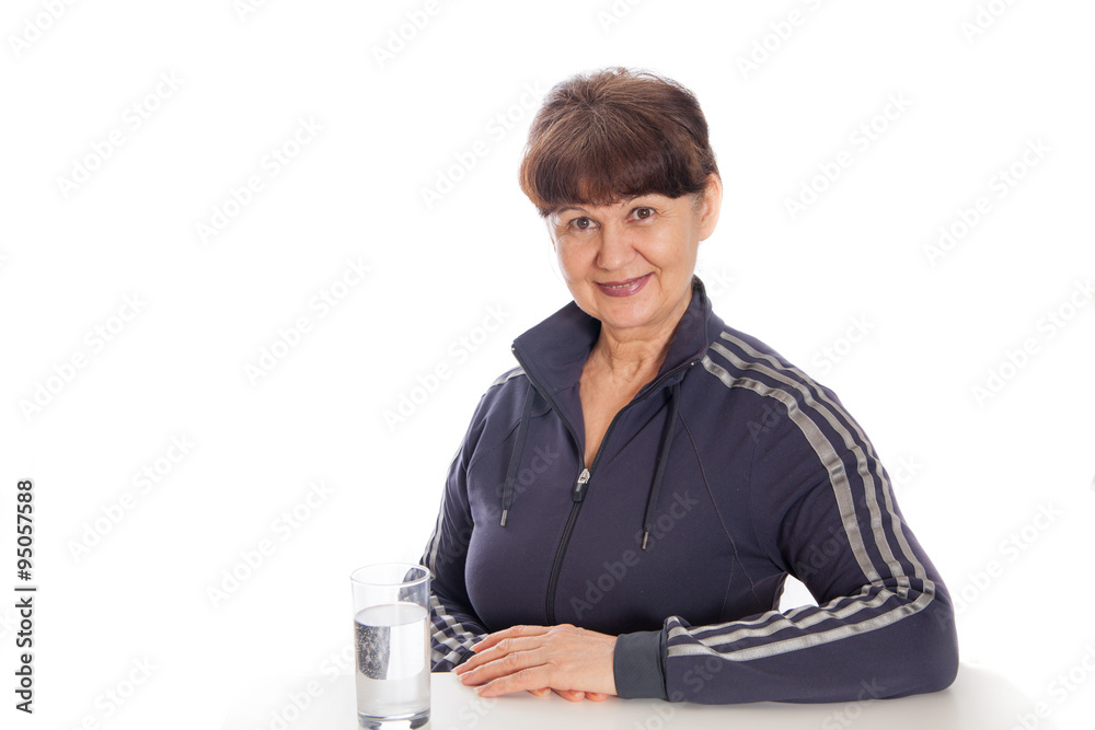 Good looking mature woman with glass of water posing after her sport session Good looking mature woman with glass of water posing after her sport session