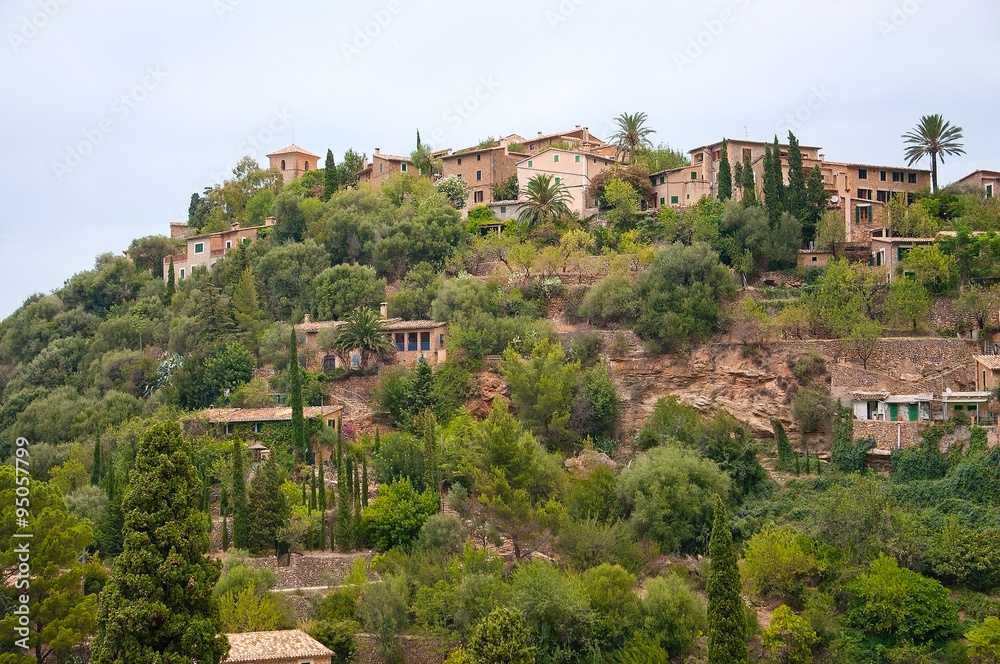 Lush hills near Deia with traditional drystone buildings on an overcast day in July in Mallorca, Balearic islands, Spain.