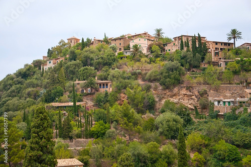 Lush hills near Deia with traditional drystone buildings on an overcast day in July in Mallorca, Balearic islands, Spain.