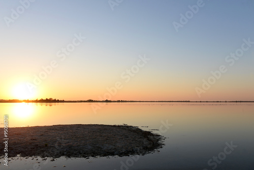 Golden sunrise over calm water