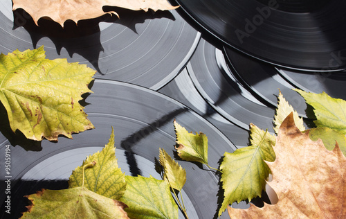 Background of vinyl records and autumn leaves. photo