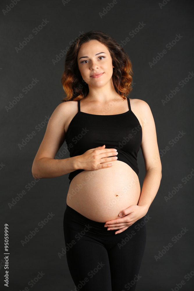 Young happy pregnant woman on black background Young happy pregnant woman on black background