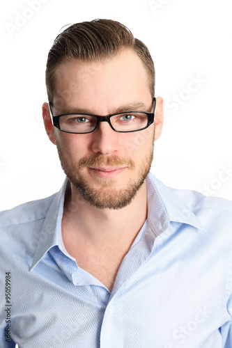 Fototapeta Naklejka Na Ścianę i Meble -  A handsome man in his 20s, wearing a blue shirt and glasses smiling. White background.