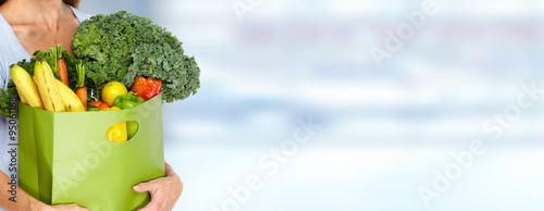 Woman hands with grocery bag of vegetables.