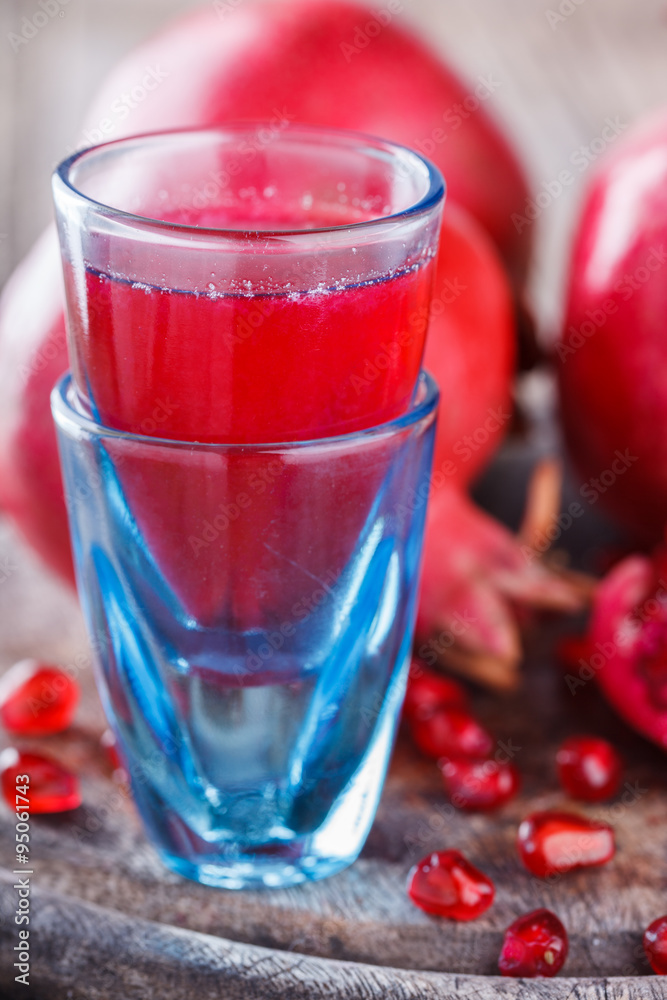 Juicy pomegranates,whole and broken and pomegranate juice on wooden background.selective focus. Juicy pomegranates,whole and broken and pomegranate juice on wooden background.selective focus.