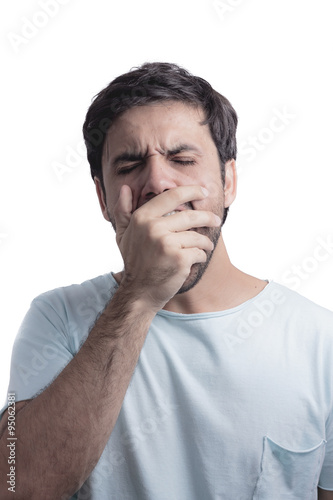 Young man yawning with his hand on face
