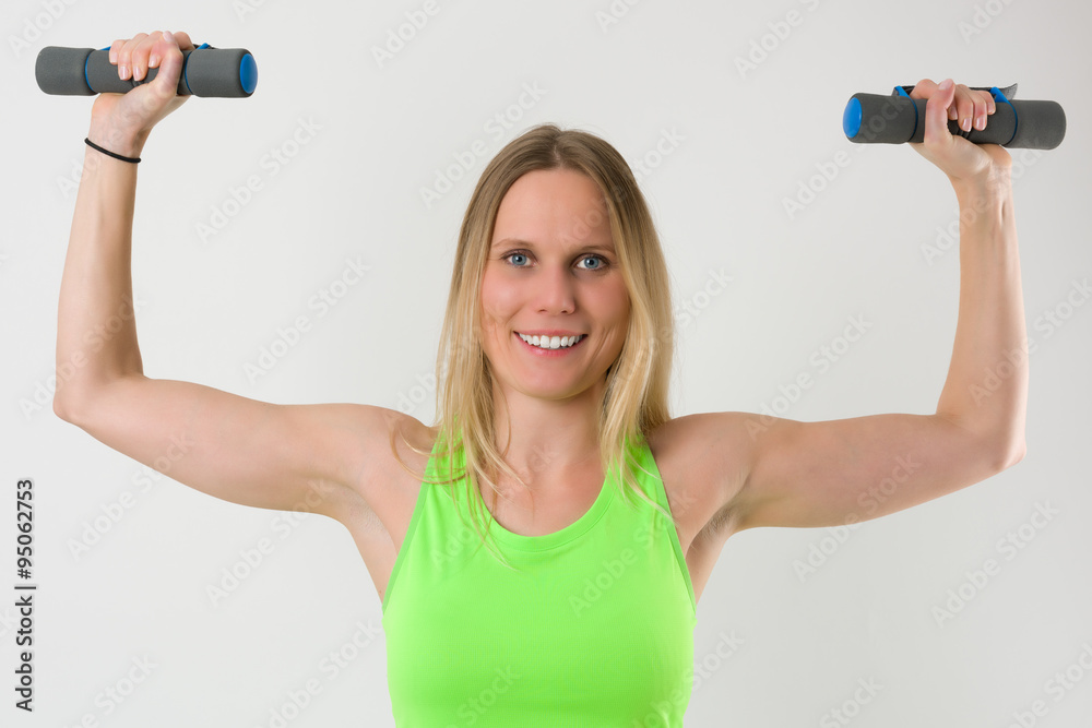 Smiling blond woman doing exercises with dumbbells Smiling blond woman doing exercises with dumbbells