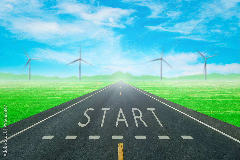 Fototapeta premium road through the green field with sign start on asphalt