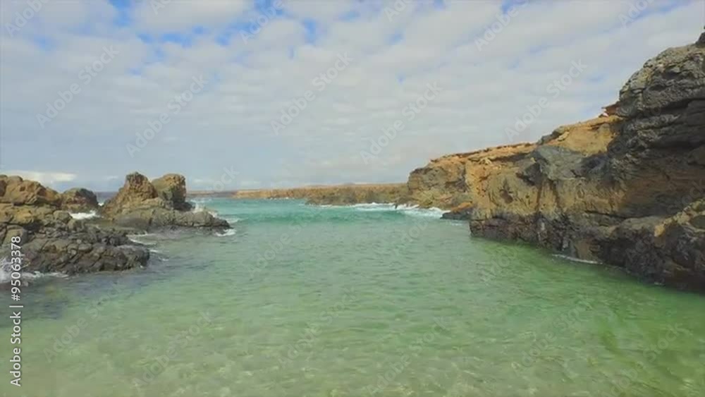 AERIAL: Beautiful exotic beach hidden between the rocky reef AERIAL: Beautiful exotic beach hidden between the rocky reef