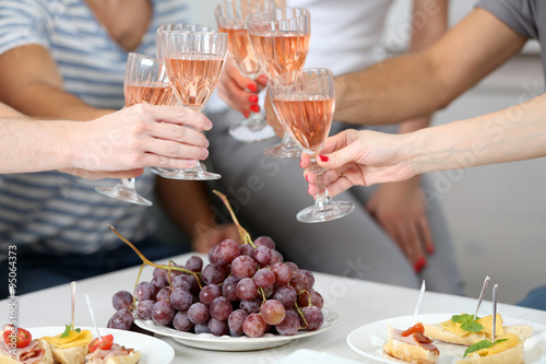 Friends hands with glasses of wine and snacks  close up