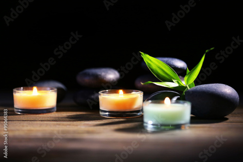 Spa stones and candles on dark background