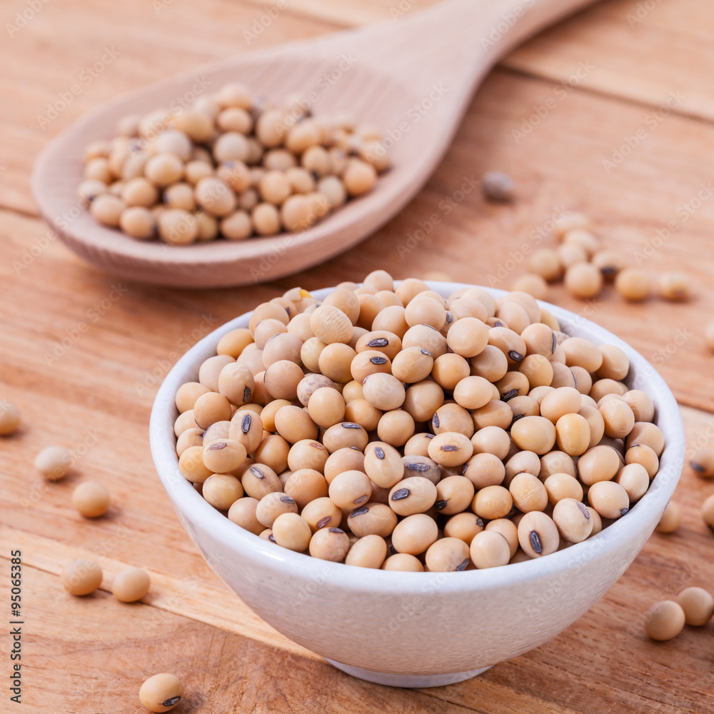 Close Up soy beans in wooden bowl and spoon on wooden background Close Up soy beans in wooden bowl and spoon on wooden background