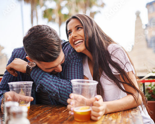 Fotografia hispanic couple laughing and having fun while drinking beer