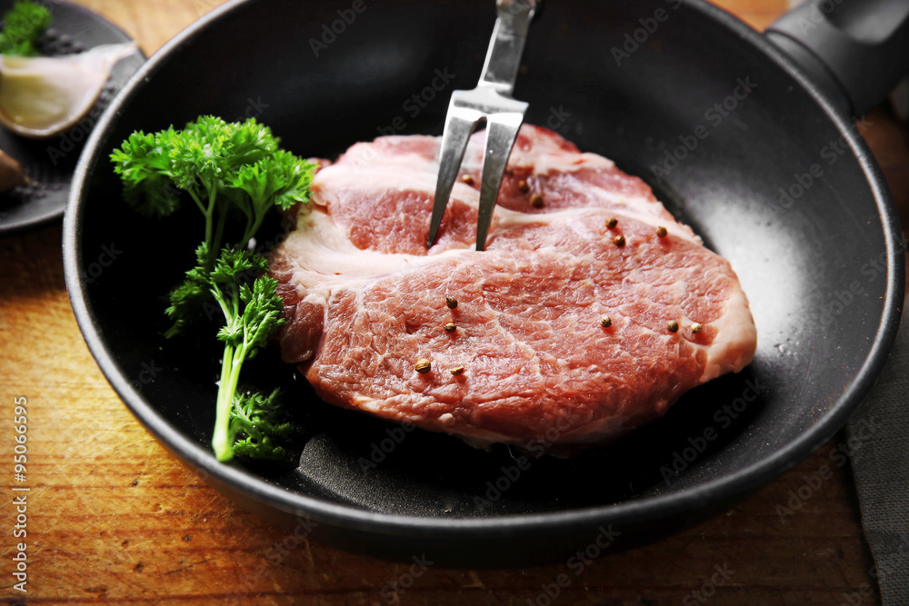 Marbled beef steak on pan and spices on wooden background Marbled beef steak on pan and spices on wooden background