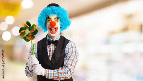 Foto portrait of a funny clown holding a pinwheel