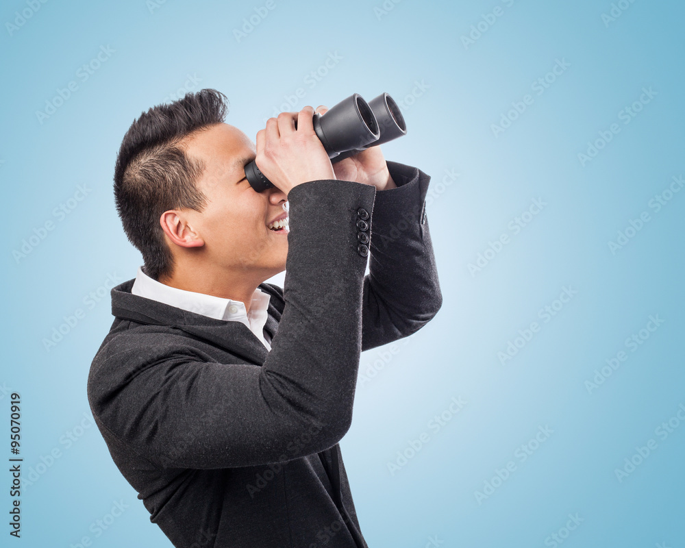handsome young asian man looking trough a binoculars handsome young asian man looking trough a binoculars