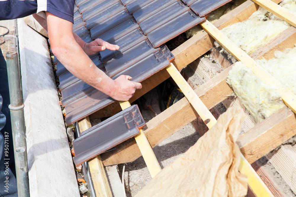 a roofer laying tile on the roof a roofer laying tile on the roof