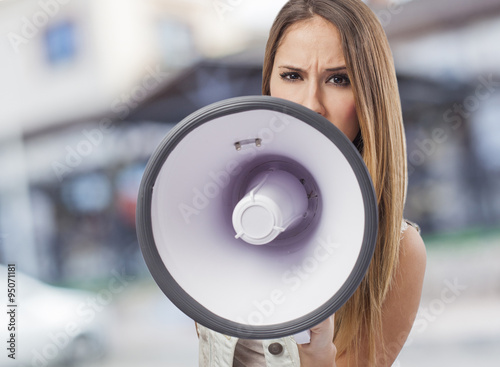beautiful young woman shouting with a megaphone © asierromero