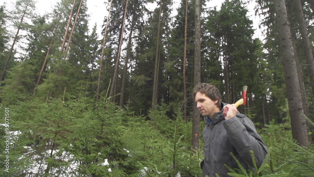 SLOW MOTION: Man with an axe walking in forest SLOW MOTION: Man with an axe walking in forest