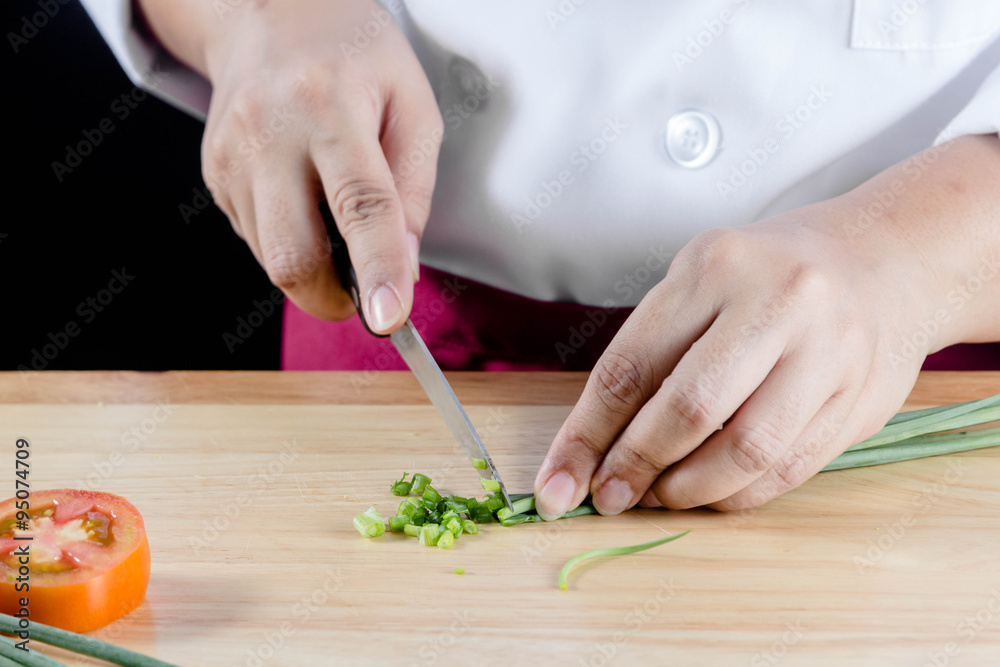 Obraz premium chef chopped green onions or spring onions on wooden board