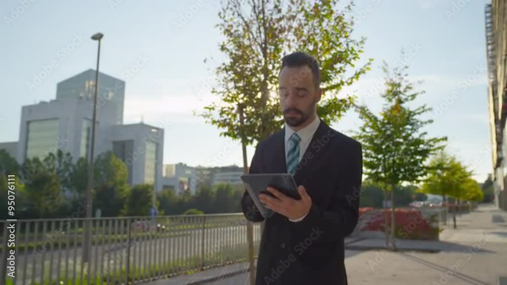 SLOW MOTION: Worried businessman checking news on digital tablet outdoors SLOW MOTION: Worried businessman checking news on digital tablet outdoors