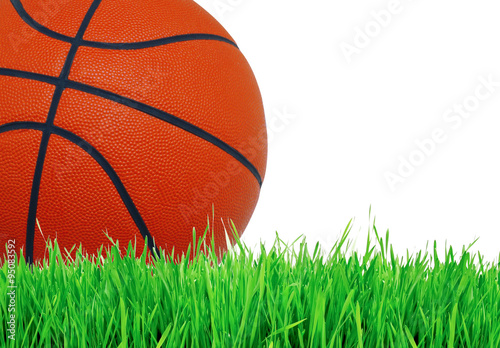 Basketball ball on green grass over white  close up