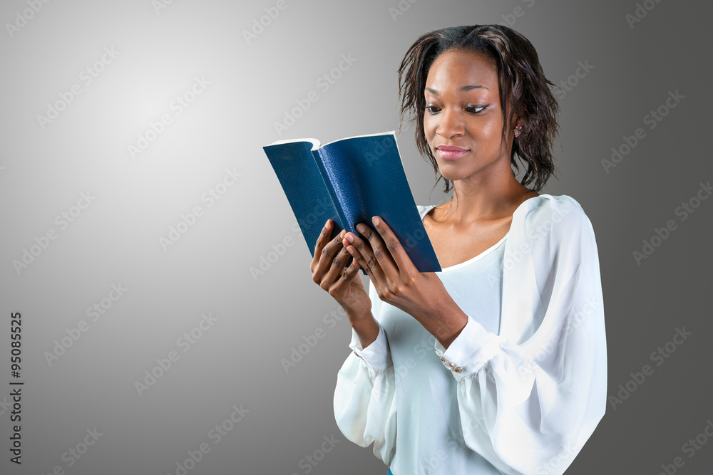 Fototapeta premium Close-up portrait of a young african woman with a book
