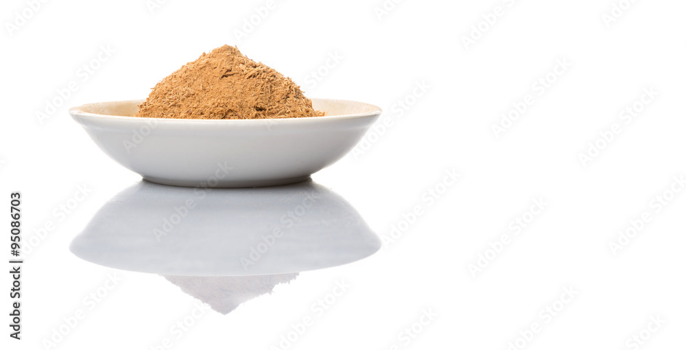 Dried galangal powder in white bowl over white background Dried galangal powder in white bowl over white background