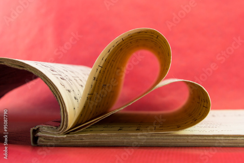 Music notation book with pages shaping heart closeup
