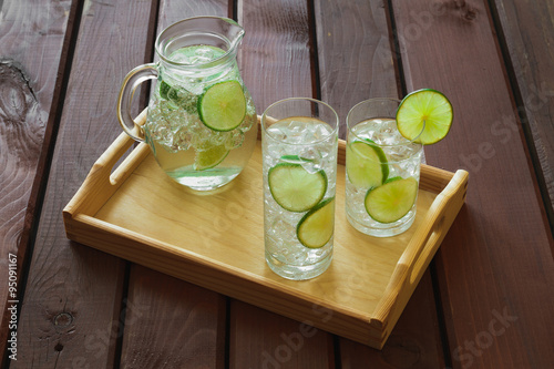Obraz na płótnie Two drinks and jug on wooden tray with ice and condensation on g w salonie