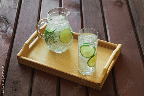 Obraz na płótnie Drink and jug on wooden tray with ice and condensation on glass w salonie