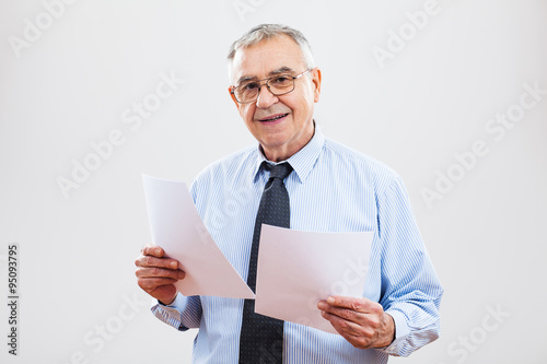 Portrait of successful senior businessman holding documents