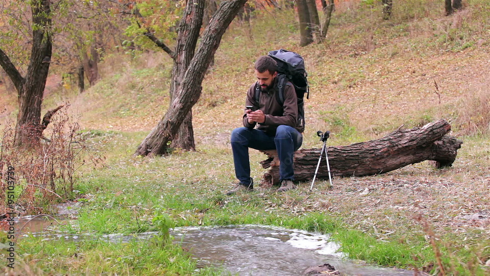 Man tourist with a backpack. Selfie in the forest.