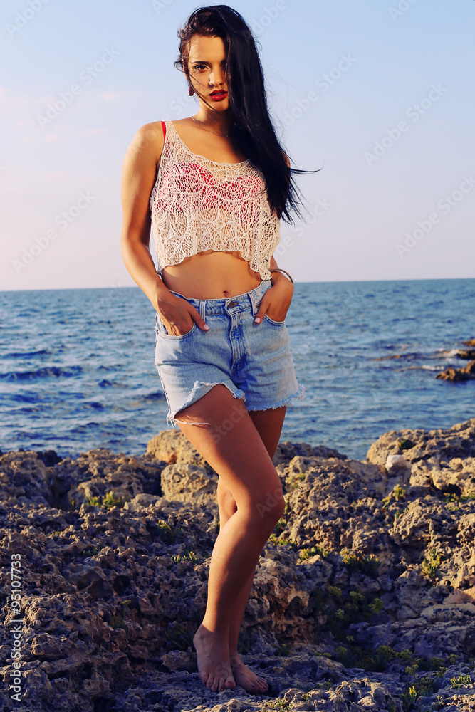 sexy beautiful woman wears a top with jeans shorts and posing