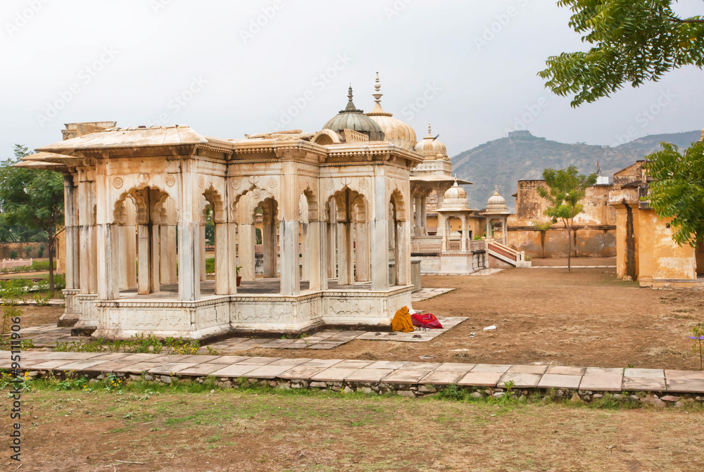 Indian women sleep near the Gaitore Cenotaphs with typical Rajasthani Carvings