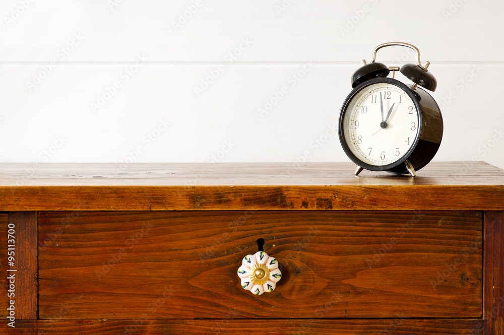 Retro alarm clock on bedside table, background white wooden wall Retro alarm clock on bedside table, background white wooden wall